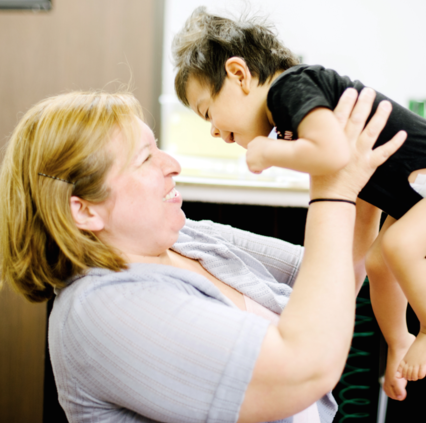Woman lovingly lifting up visually impaired boy