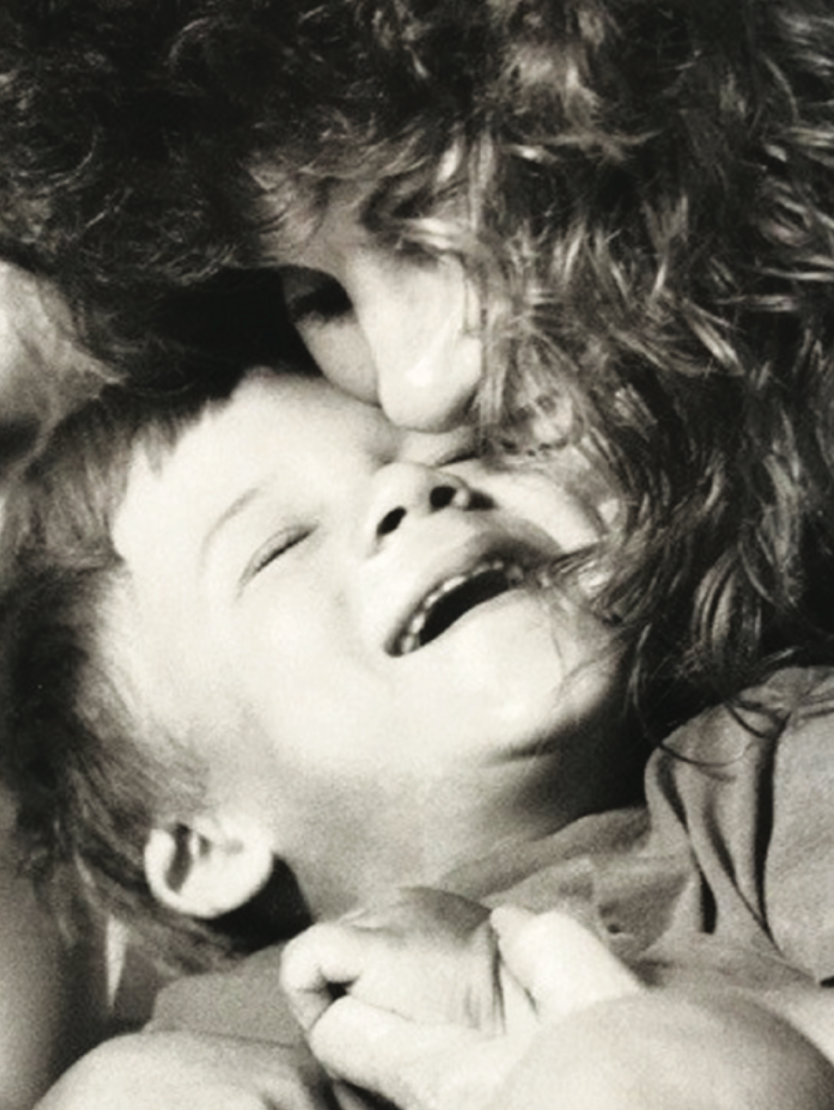 Visually impaired boy receives kiss from mother