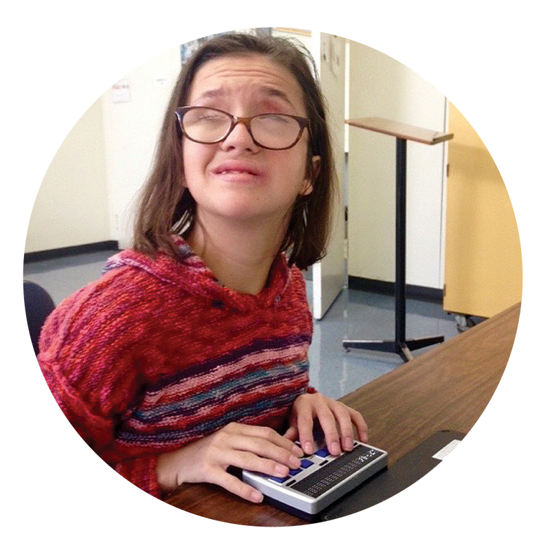 Young girl learning to use Braille device